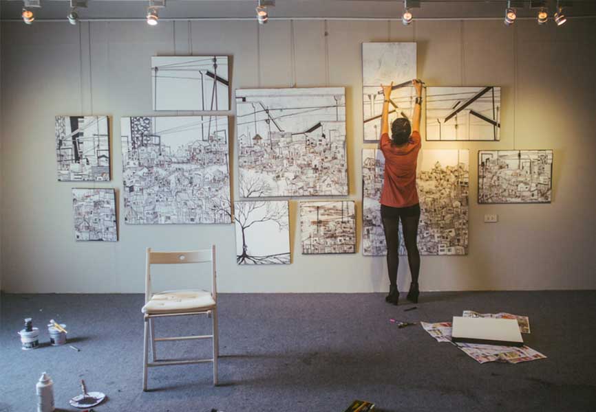 Woman working on paintings on a wall